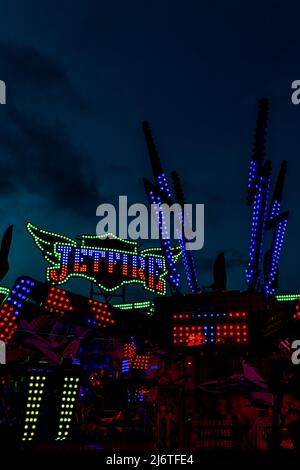 The blue and red lights of the Jetfire funfair ride brighten the night ...