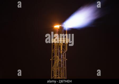 Flare stack and flare platform while burning gases from processing at oil and gas platform, offshore oil and gas business in the gulf of Thailand. Stock Photo