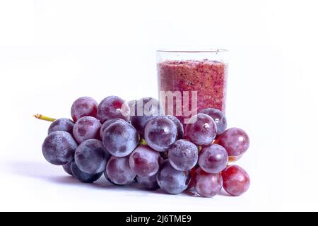 A glass of grape juice with red grapes fruits isolated on white background. Stock Photo