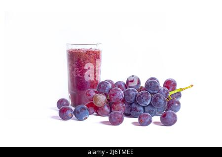 A glass of grape juice with bunch of grapes fruits isolated on white background. Stock Photo