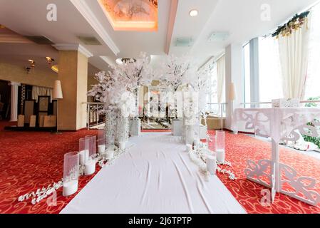 Arch for the wedding ceremony, which is decorated with floral compositions and a pink cloth and candles in rustic style Stock Photo