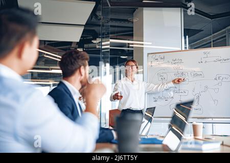 businesswoman explaining her business plan to colleagues while making a presentation in the office Stock Photo
