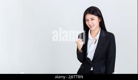 pretty young asian business woman hands up happy in the success. Stock Photo