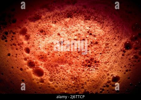 Dark red image of foam on liquid surface. Abstract red foam background. Stock Photo