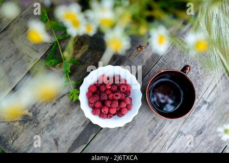 Still life of flowers, raspberries and tea Stock Photo