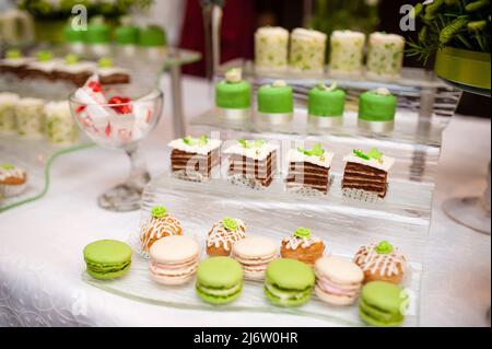 Multi-colored cakes and sweets on the festive table. Stock Photo
