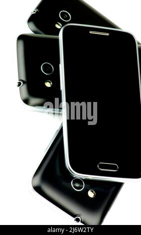 Pile of Contemporary Black and Silver Smartphones isolated on White background Stock Photo