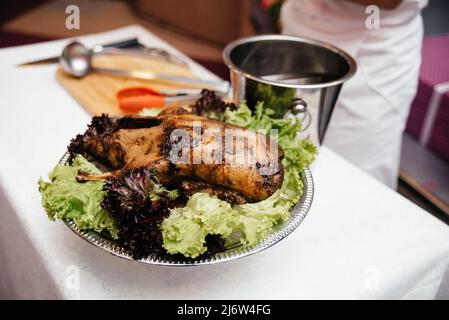 Baked duck on a platter with vegetables and salad. Stock Photo