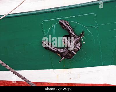 Close-up of black anchor on colorful ship hull Stock Photo