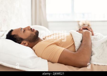 Arabic Young Man Sleeping Lying On Back Resting In Bedroom Stock Photo