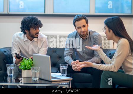 Team of coworkers holding their meeting in a modern office Stock Photo