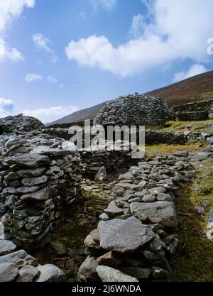 View NW of beehive huts (clochans) within the circular stone wall of Caher Martin cashel (fort), Glanfahan, Dingle, County Kerry, Republic of Ireland. Stock Photo