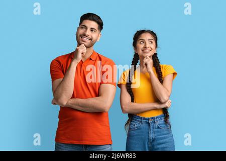 Portrait Of Thoughtful Young Arab Man And Woman Standing On Blue Background Stock Photo