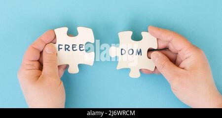 The word freedom is standing on puzzle pieces, new normal, covid-19 regulations, changing lifestyle, free speech Stock Photo