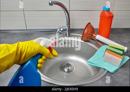 Hands in yellow rubber gloves hold a spray bottle with cleaning agen Stock Photo