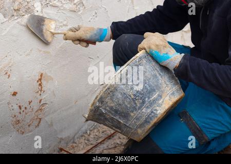 Unrecognizable man applying concrete on house facade Stock Photo