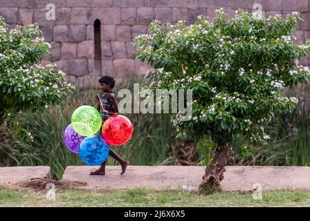 Vellore, Tamil Nadu, India - September 2018: A young Indian boy selling colorful balloons in a park. Stock Photo