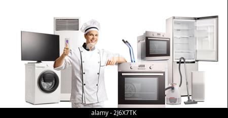 Male chef gesturing thumbs up and posing with electrical home appliances isolated on white background Stock Photo