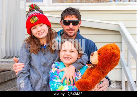 Happy single parent working class family posing for the camera in Ludington, Michigan, USA. Stock Photo