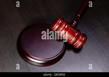 Law theme. Court of law trial in session. Judge gavel on wooden table in lawyer office or court session. Mallet of judge on dark background. Justice human rights concept flat lay top view Stock Photo