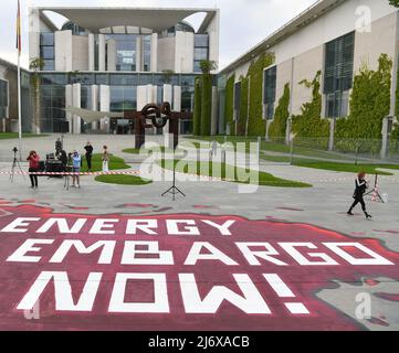 04 May 2022, Berlin: 'Energy Embargo now' is written in chalk on the ground at the Federal Chancellery. There, numerous people met and protested against the war in Ukraine and demanded an energy embargo against Russia on posters and in chants. Photo: Paul Zinken/dpa Stock Photo