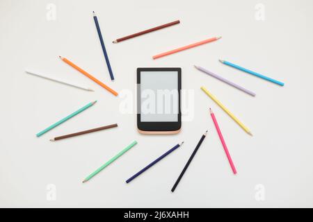 Digital tablet and colorful pencils on white background. Painting, hobby concept. Stock Photo