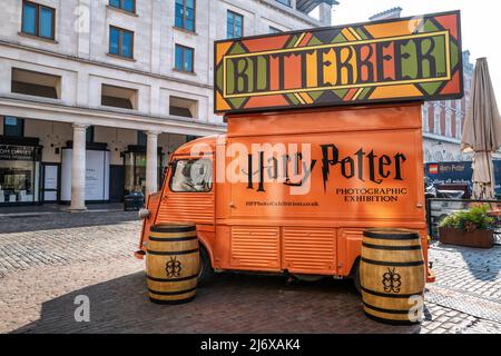 London, UK - 16 April 2022: Orange food and drink truck selling Butterbeer, in Covent Garden, London. This drink was make famous and popular by the Ha Stock Photo