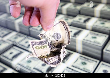 A crumpled hundred-dollar bill in his hand. The world economy no longer believes in the reliability of the dollar Stock Photo