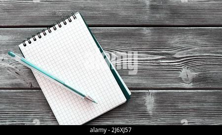Spiral notebook on the table. There is a ballpoint pen next to it for writing Stock Photo