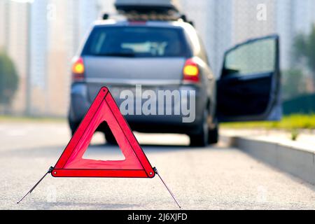 Red warning triangle with a broken down car. Stock Photo