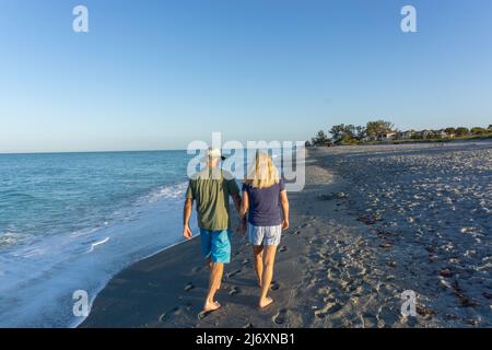 Retired couple holding hands on beach in Florida Stock Photo