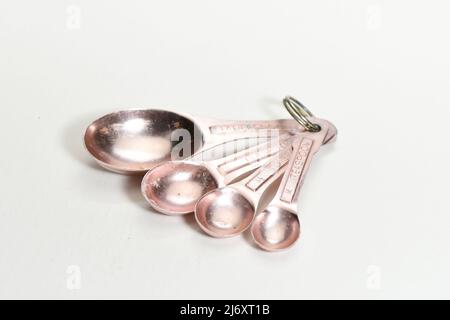 Well-used metal kitchen measuring spoons used in cooking isolated on white background Stock Photo
