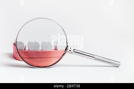 Magnifying glass with white tooth model Dental Health concept Stock ...