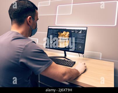 Young dentist examining an x-ray on computer in dental clinic Stock Photo