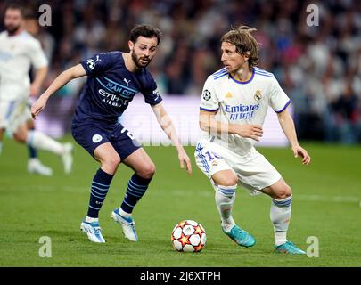 Real Madrid's Luka Modric, right, heads the ball past Manchester