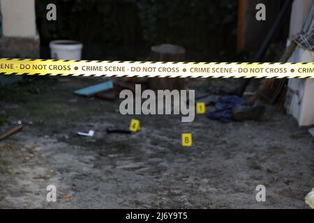 Crime scene tape for covering the area cordon. Yellow tape with blurred forensic law enforcement background in cinematic tone and copy space Stock Photo