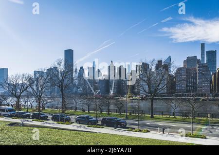 New York City, USA - February 20, 2022: New York City skyline from Roosevelt island over the East river. Cranes on the river. Skyscrapers of Midtown M Stock Photo