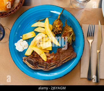 Portion of just cooked churrasco with potatoes and artichokes Stock Photo