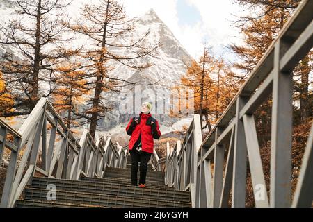 asian woman female tourist walking on steps at the foot of mount chenrezig in yading national park in daocheng county, sichuan province, china Stock Photo