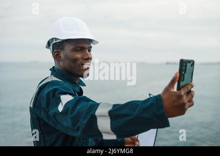 Black seaman having remote conversation with family Stock Photo