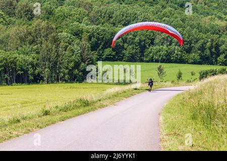 Touchdown on a country road by a paraglider Stock Photo