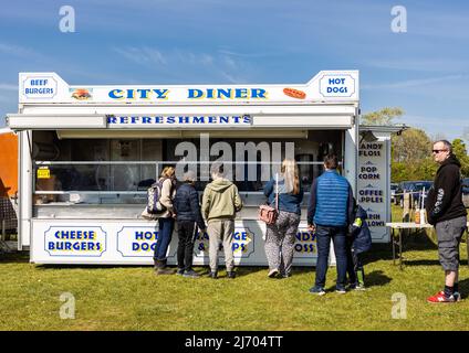 customers in line queuing for the burger and refreshments trailer at the local car boot sale, Hertfordshire England UK Stock Photo