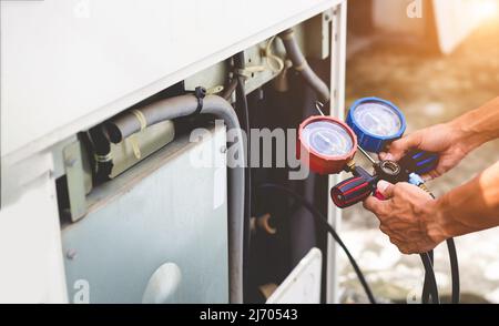 Technician checking air conditioning operation, detecting refrigerant