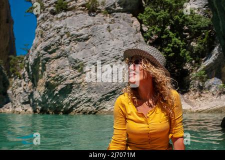 Cheerful attractive adult woman smile and enjoy canoe jayaj trip journey on a blue river in a canyon. Tourist and outdoor new leisure activity. Summer Stock Photo