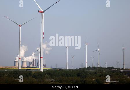 03 May 2022, North Rhine-Westphalia, Erkelenz: RWE wind turbines rotate at the Garzweiler open pit mine in front of the Neurath power plant. Photo: Oliver Berg/dpa Stock Photo