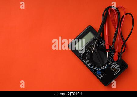 Multimeter on orange background, space for text Stock Photo