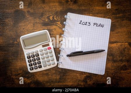 calculator and notepad with text 2023 Plan on wooden table Stock Photo
