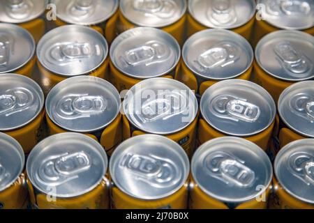 A pallet of aluminum cans with pull tabs wrapped in plastic foil Stock Photo