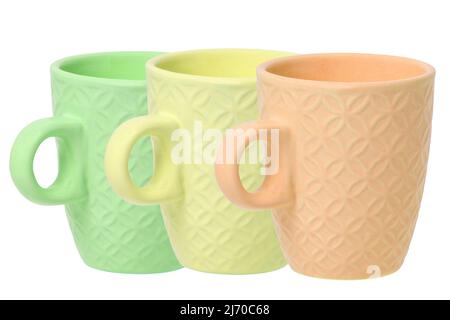 Mug of coffee. Closeup of three empty green, yellow and orange ceramic cups with space for label isolated on a white background. Concept morning coffe Stock Photo