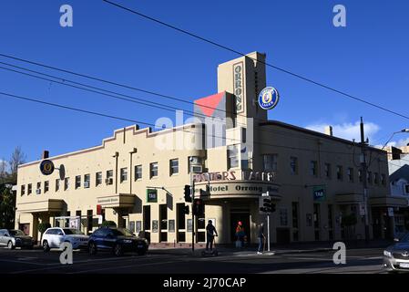 Art deco Orrong Hotel pub, with Melbourne Demons team colours painted on wall, in the late afternoon sun Stock Photo